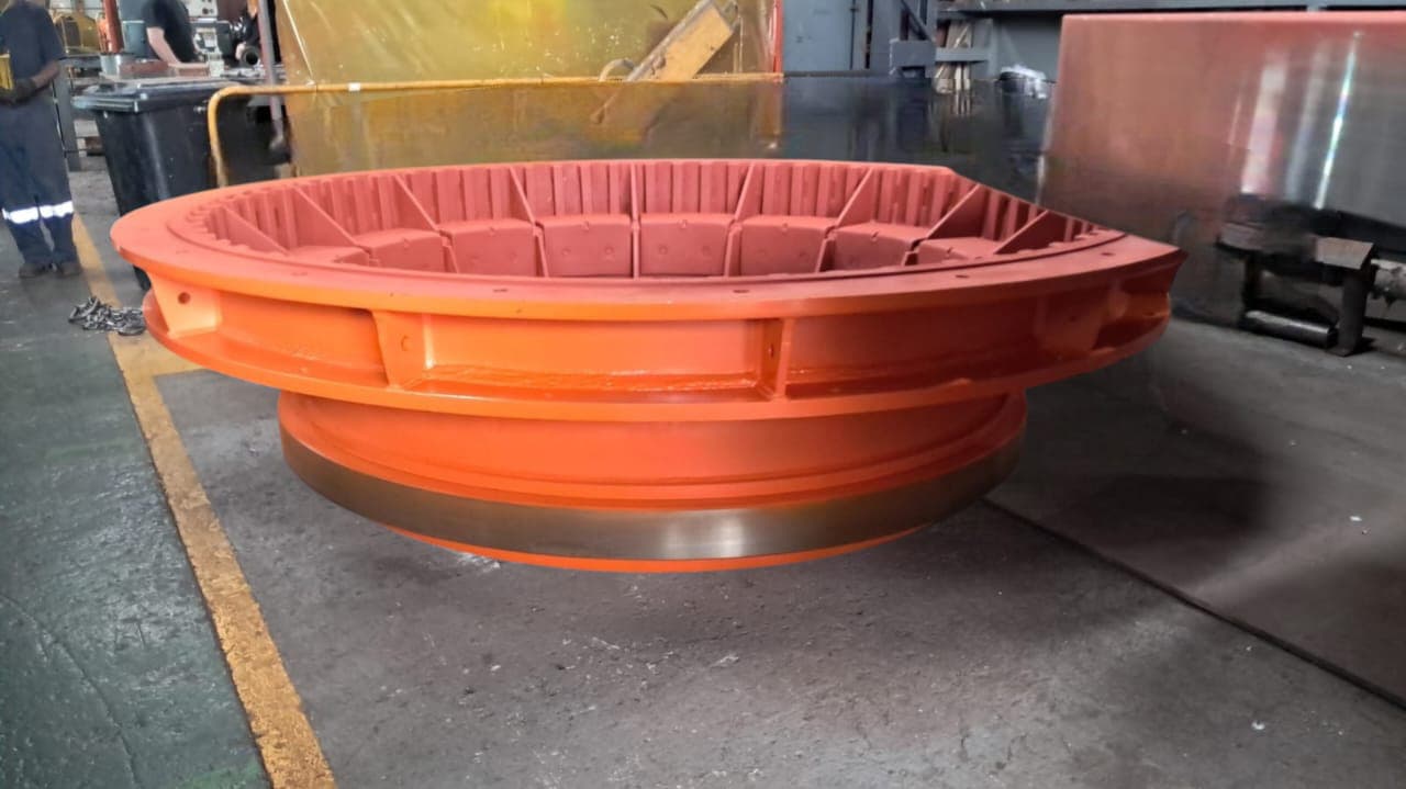 Orange fabricated circular ring component in the workshop