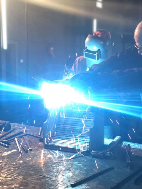 Welder working with a bright blue welding arc